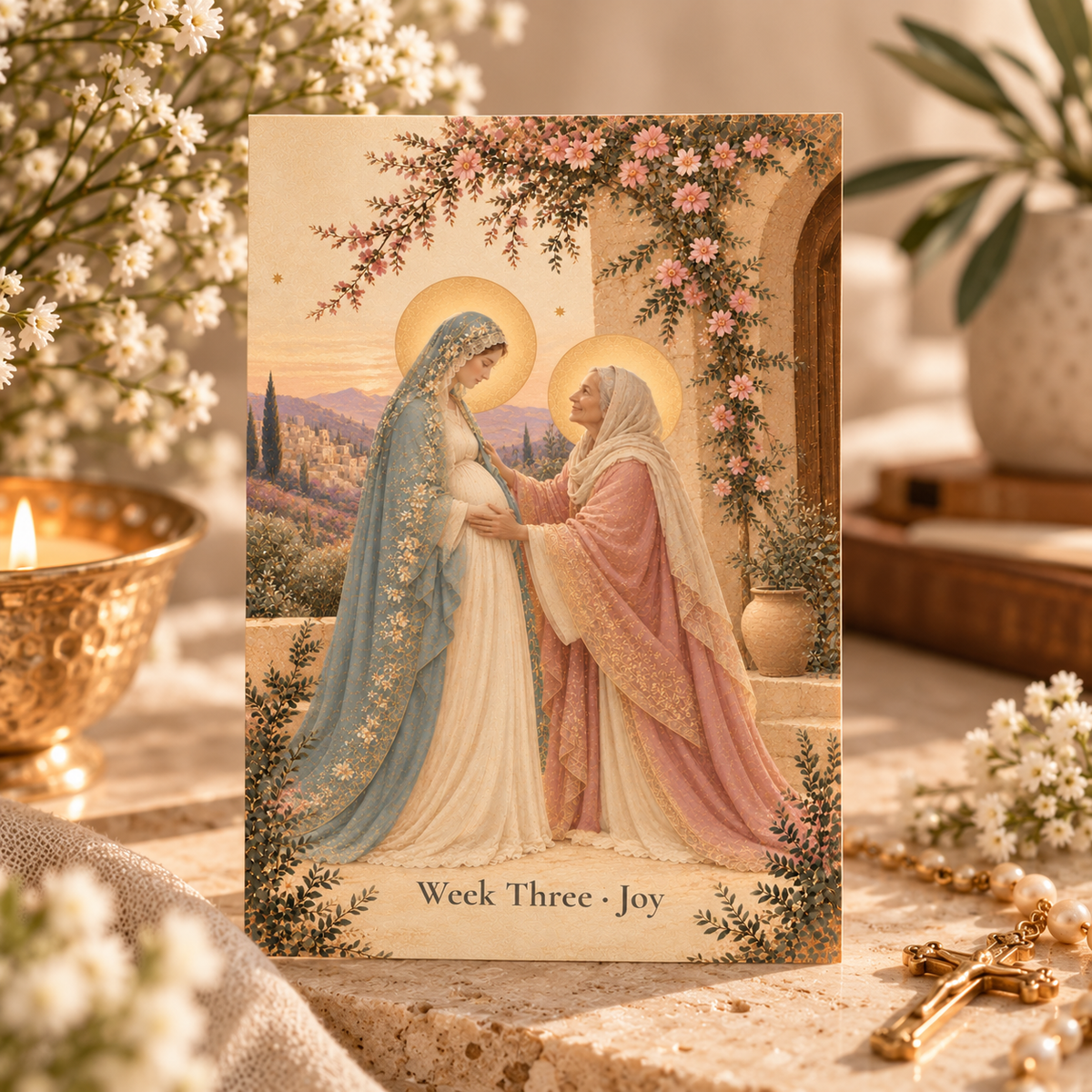 Advent prayer card Week Three Joy: the Visitation, pregnant Mary in a pale blue lace veil greeted by a smiling older Elizabeth in rose robes under pink blossoms, beside a candle and pearl rosary